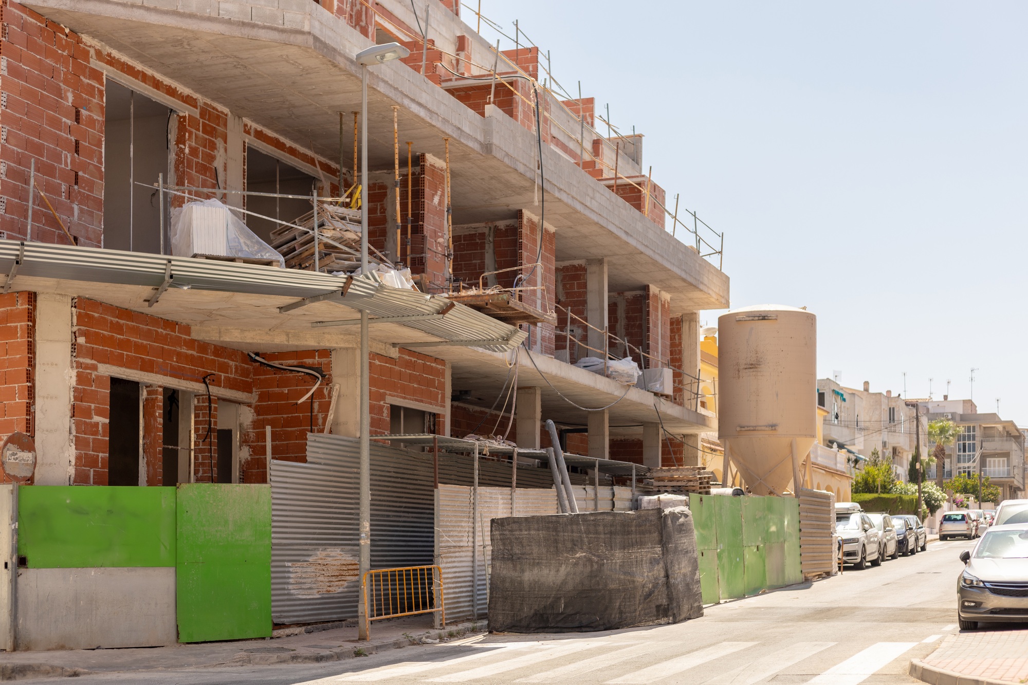 Bustling activity of construction site, showcasing multiple levels of unfinished brick